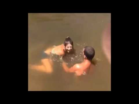 تاة تمسك سمكة بيدها من بحيرة