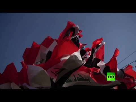 متظاهرو التحرير يزينون شجرة الميلاد بأعلام العراق