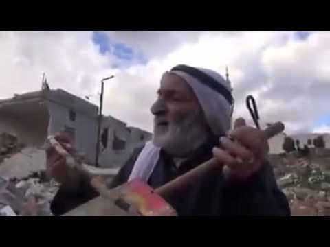 شاهد  مسن سوري يعزف لحنًا حزينًا بين الحطام