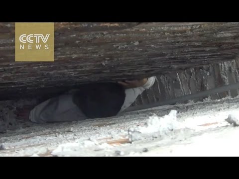 شاهد طفل سيء الحظ يقع في فتحة ضيقة بين جدارين